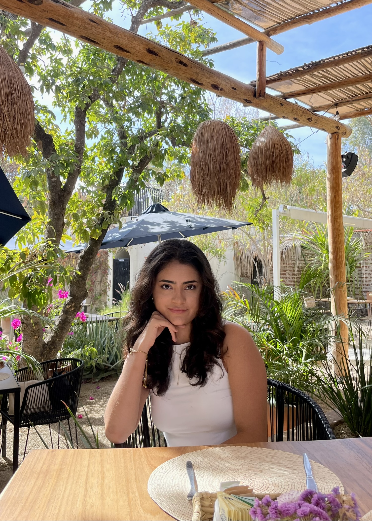 Thania Rojas sentada al aire libre entre árboles y plantas